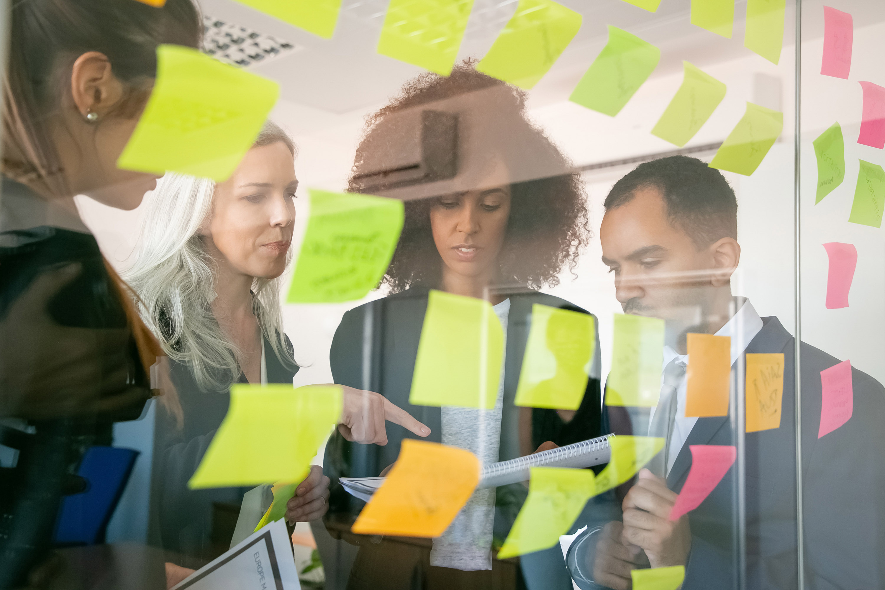 Team arbeitet mit Haftnotizen an einem agilen Planungsboard