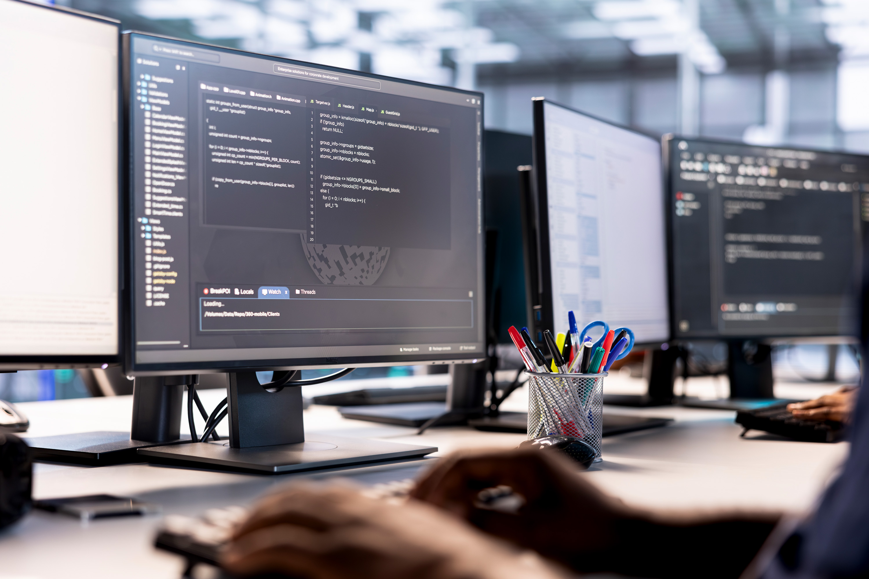 Arbeitsplatz mit mehreren Monitoren und Programmierumgebung